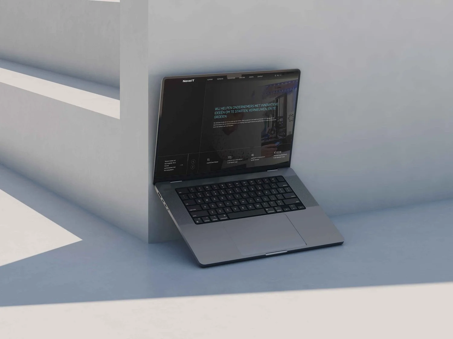 Laptop met Novel T homepage in donkere stijl tegen witte architectonische achtergrond | Minimalistisch webdesign