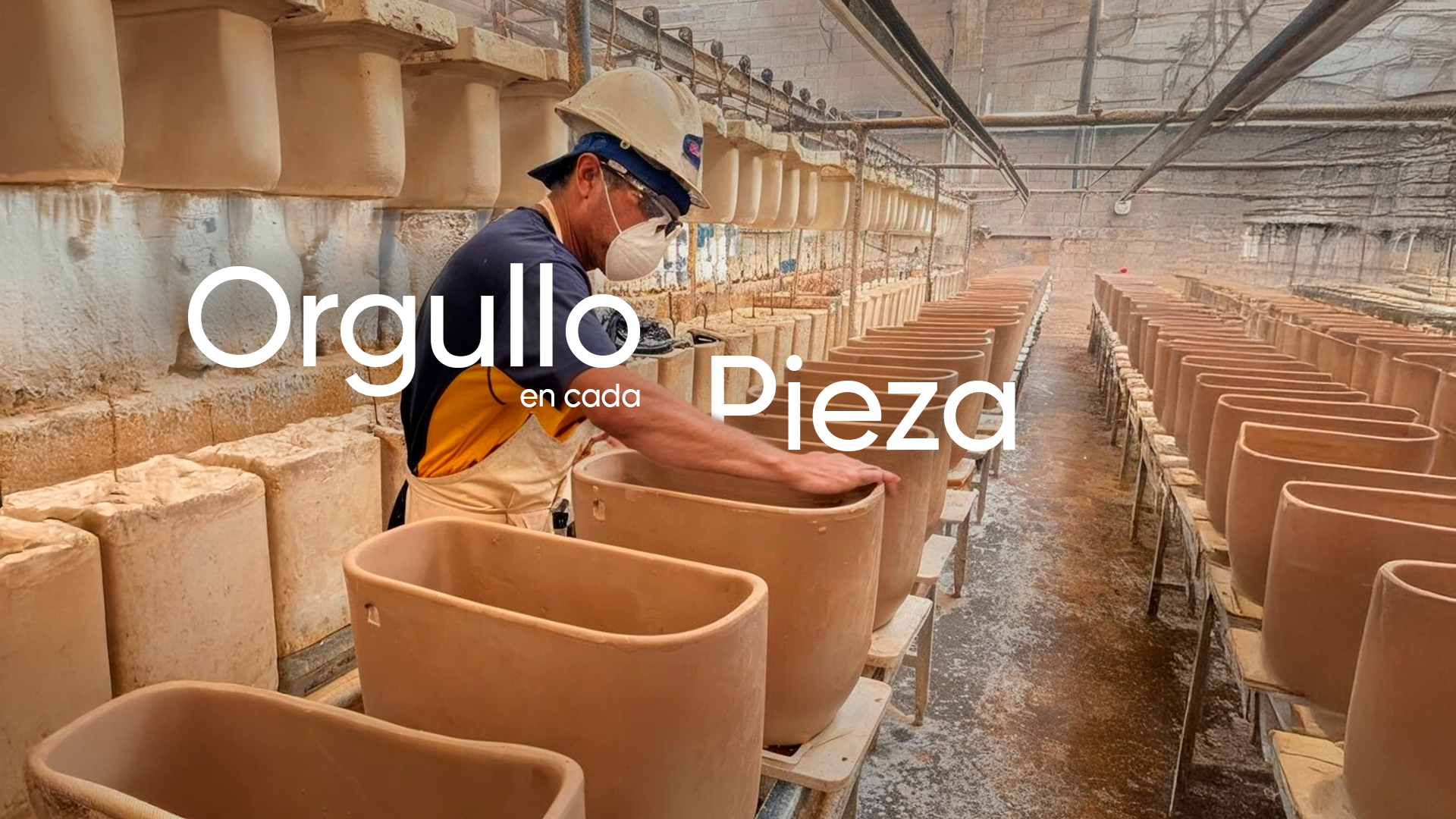 Un trabajador en una cerámica de arcilla, inspeccionando vasijas de cerámica sin esmaltar, en una línea de producción.