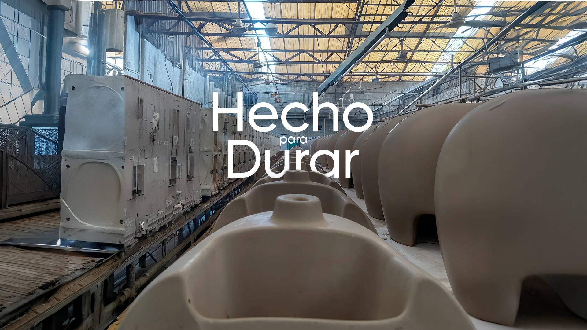 Interior de una fábrica o taller con maquinaria y moldes de cerámica o porcelana. Sobre la imagen, el texto "Hecho para Durar".