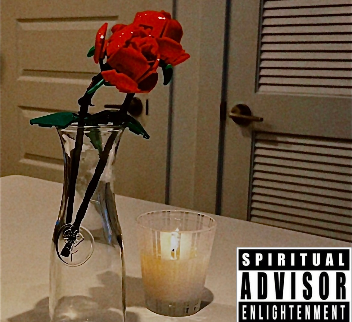 A glass vase with a bouquet of orange cloth flowers and green leaves, and a lit candle in a glass holder on a table. There is a door in the background. A spiritual advisory message is in the lower right corner.