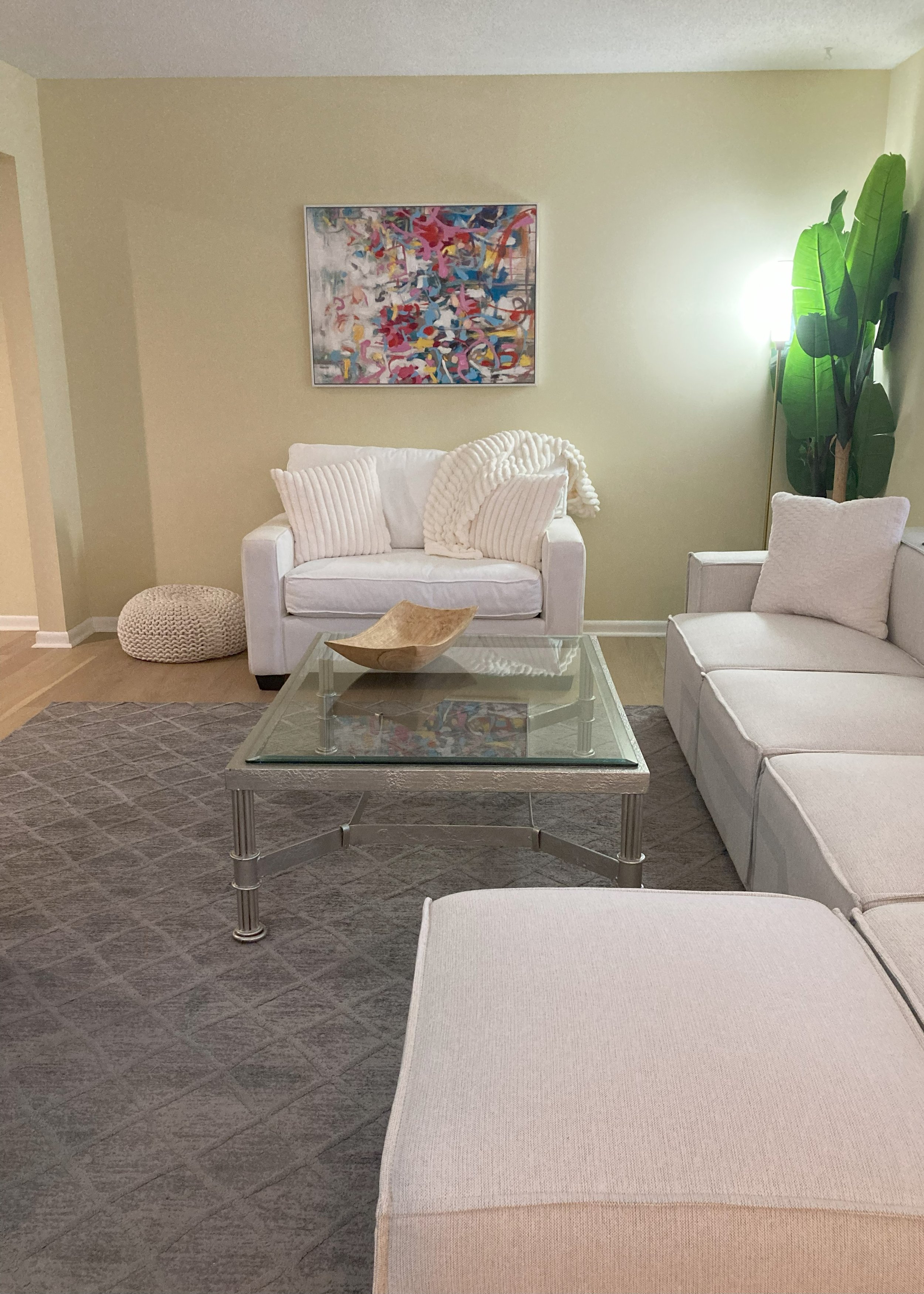 Scenic landscape of a lake surrounded by rolling hills and rugged mountains under a cloudy sky.