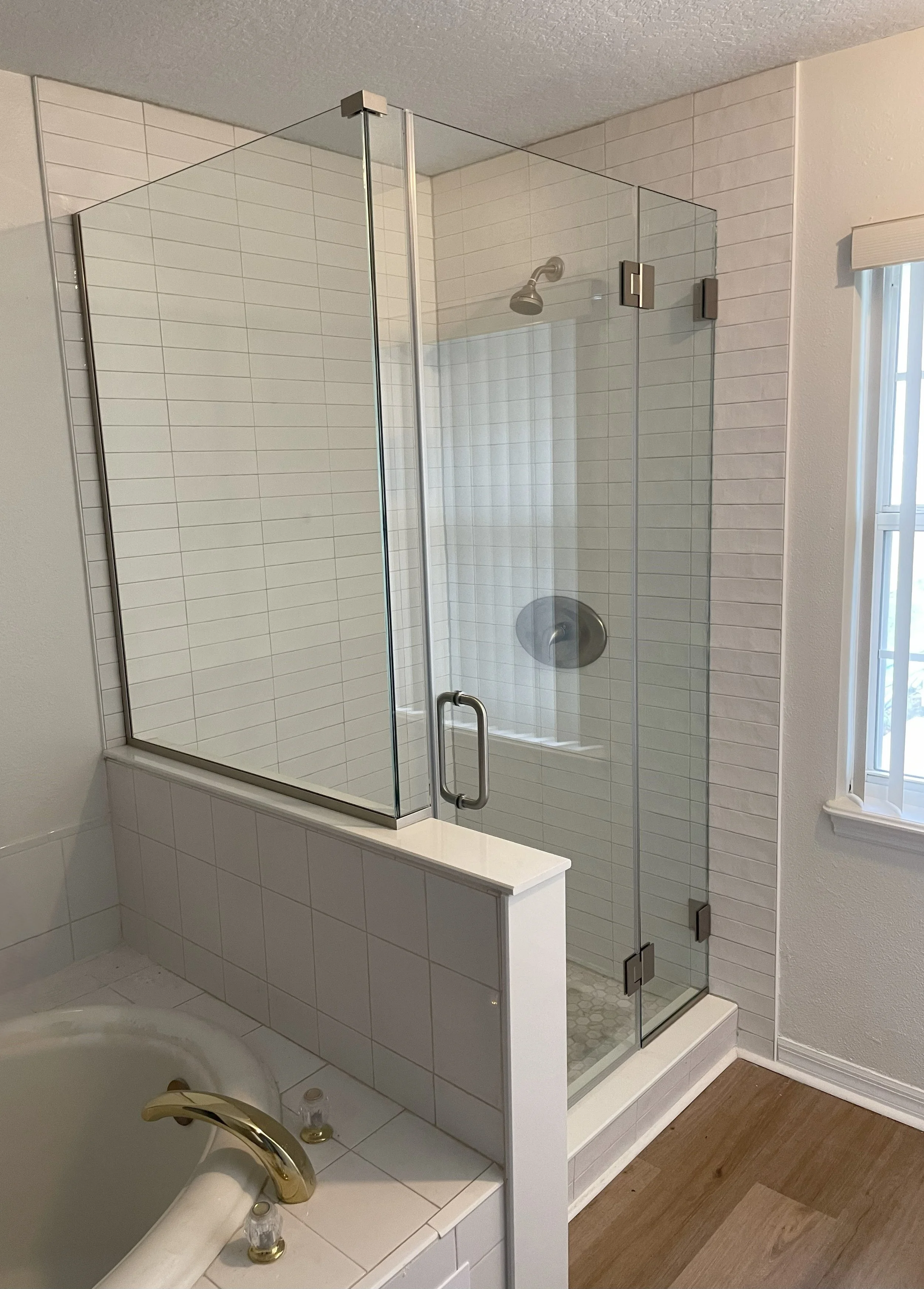 A cartoon illustration of a woman with brown hair, glasses, wearing a white blouse and pink pants, smiling and standing with her hands in her pockets.