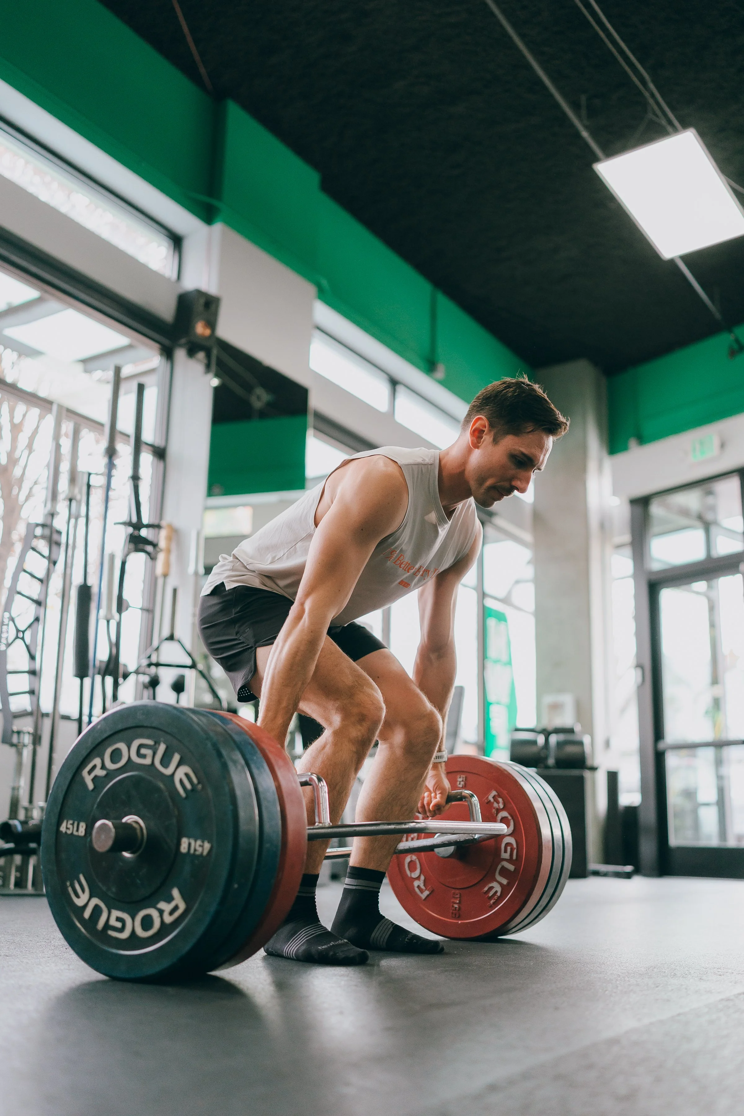 A Personal Trainer in a Seattle Personal Training Studio preparing to Deadlift a loaded barbell.