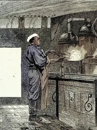 A person preparing or serving food in a kitchen with various dishes on the table, including fried chicken, salad, and bowls of food.