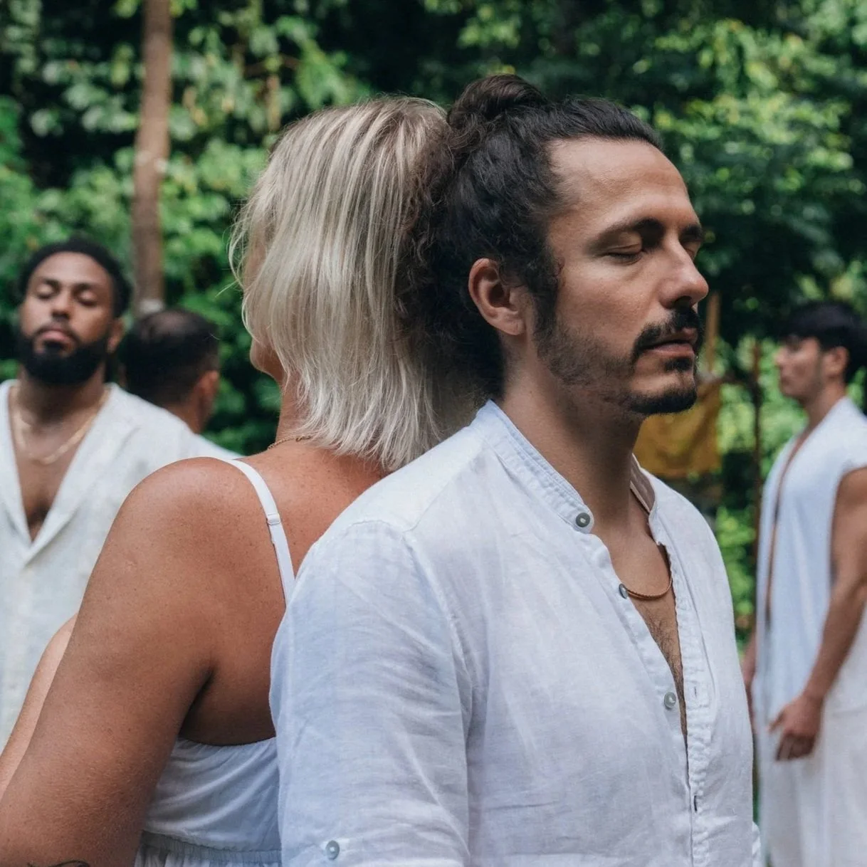 Men and women with their eyes closed, meditating.