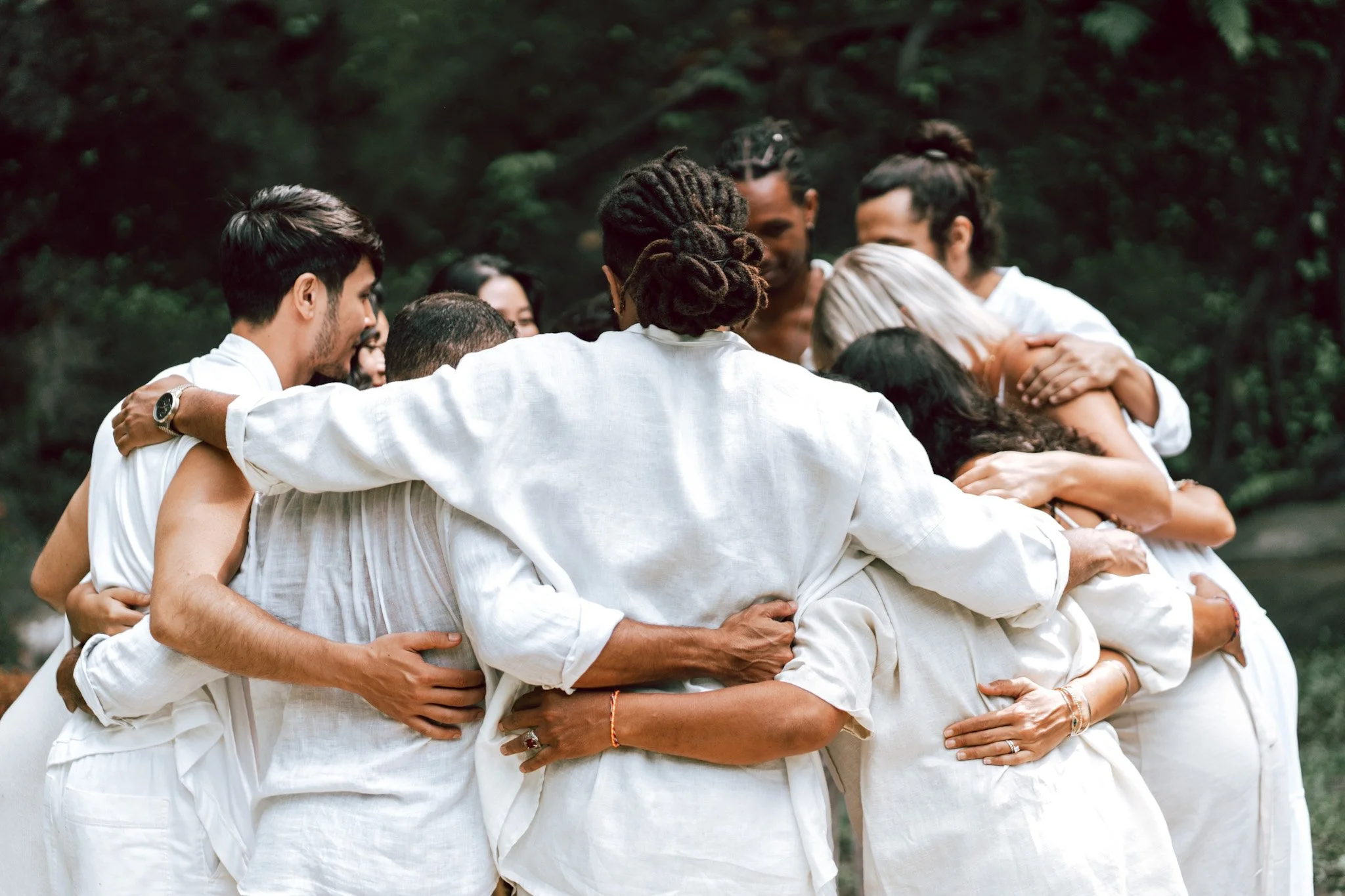 A group of people hugging while forming a circle