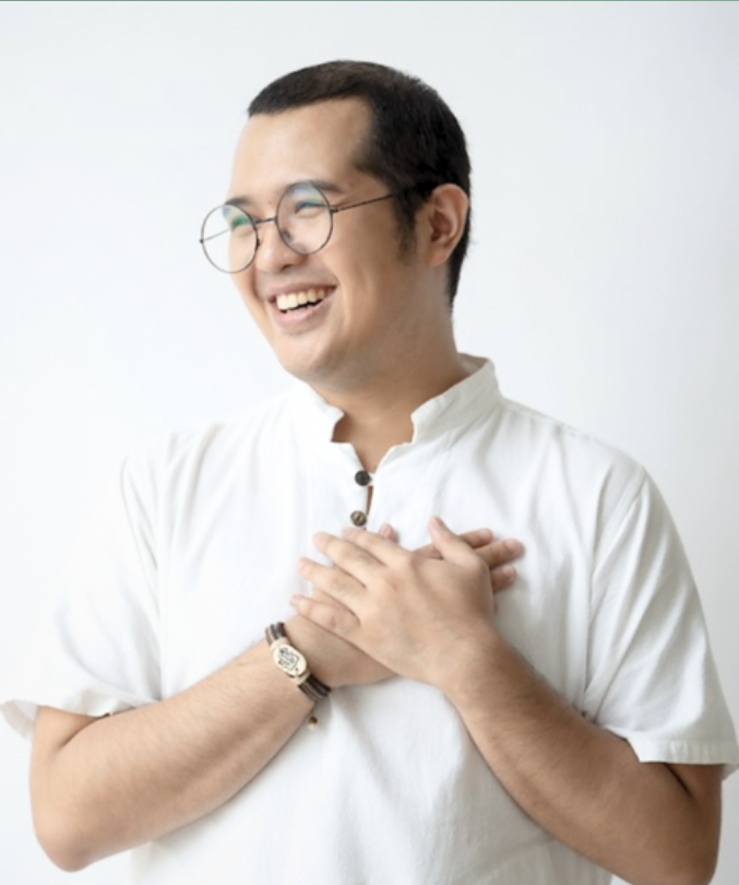 a man looking to the side with his hands placed on his chest