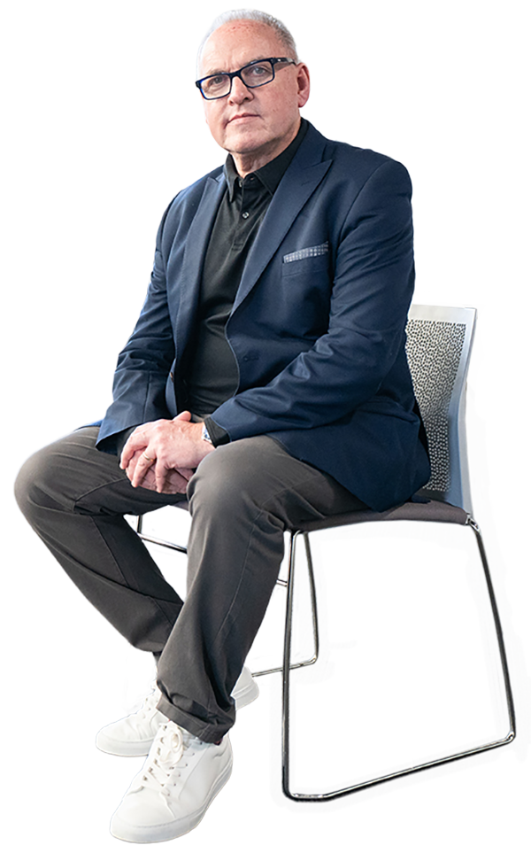 Our founder Kevin Dunckley sitting on a modern office chair with a confident look.