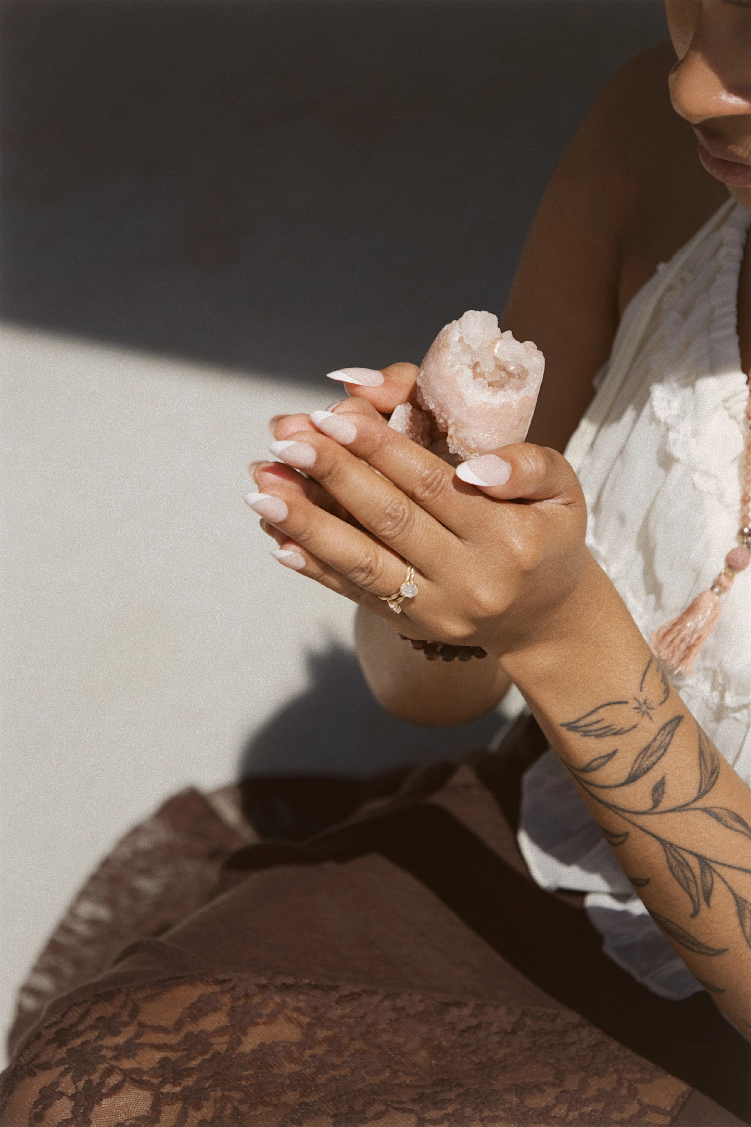 Hands holding a rose quartz crystal during a Reiki energy healing session at Beauty Charter in Sioux Falls