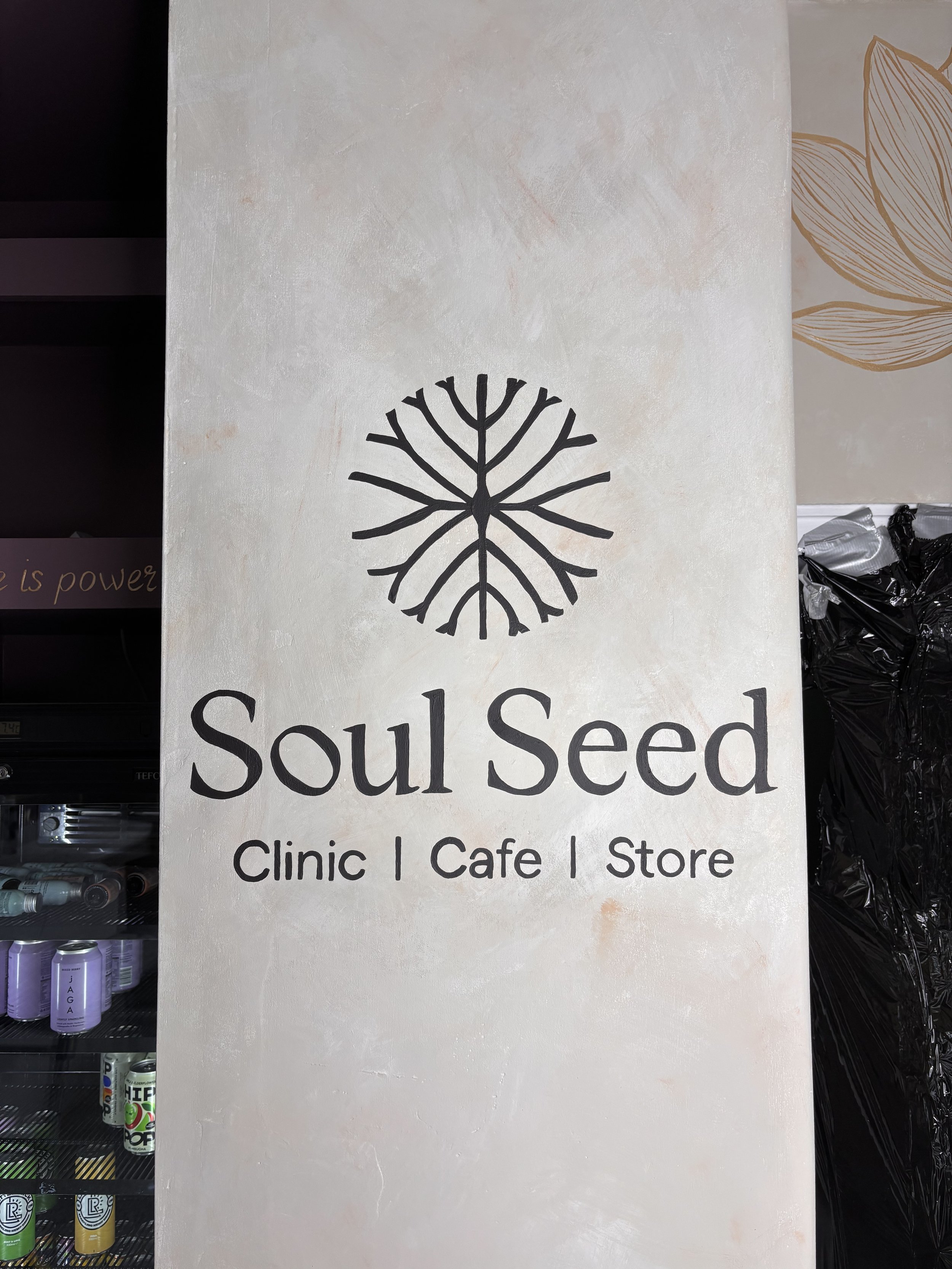 Hand-painted company logo mural on interior feature wall, created by professional mural artist for commercial branding