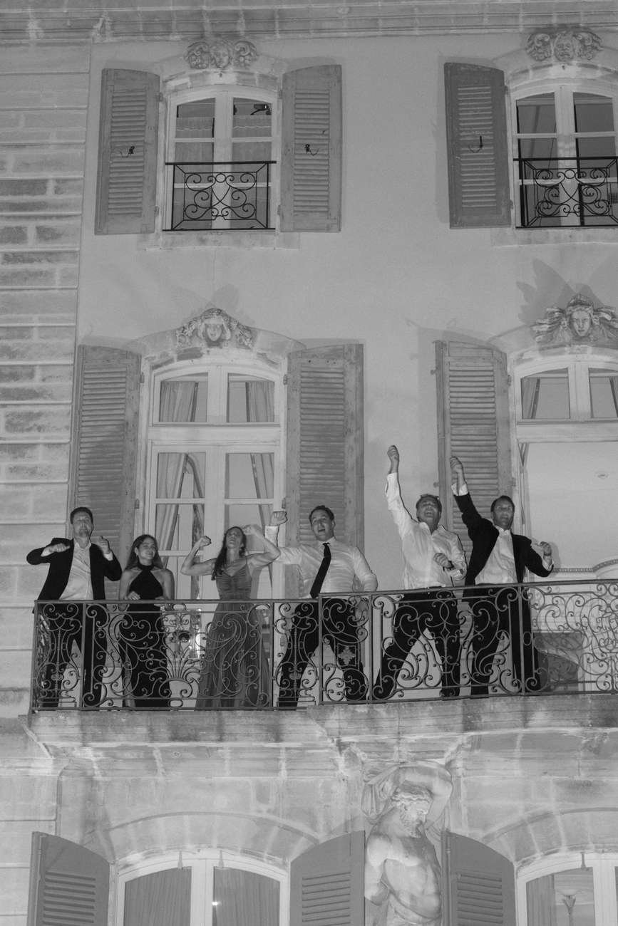 People standing on a balcony celebrating.