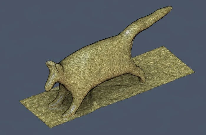 maillage d'un scan 3d d'une statue en forme de chat couché sur un tapis.