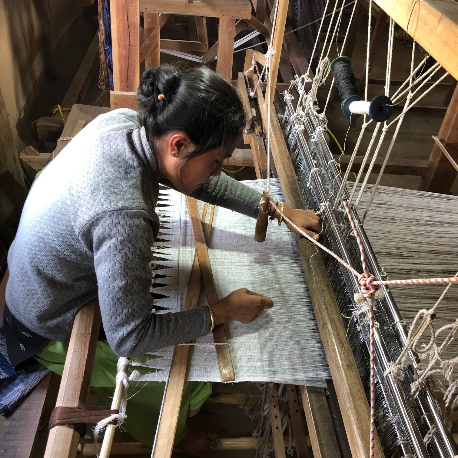 A Rabha community woman operating a traditional loom for weaving Eri silk fabric.