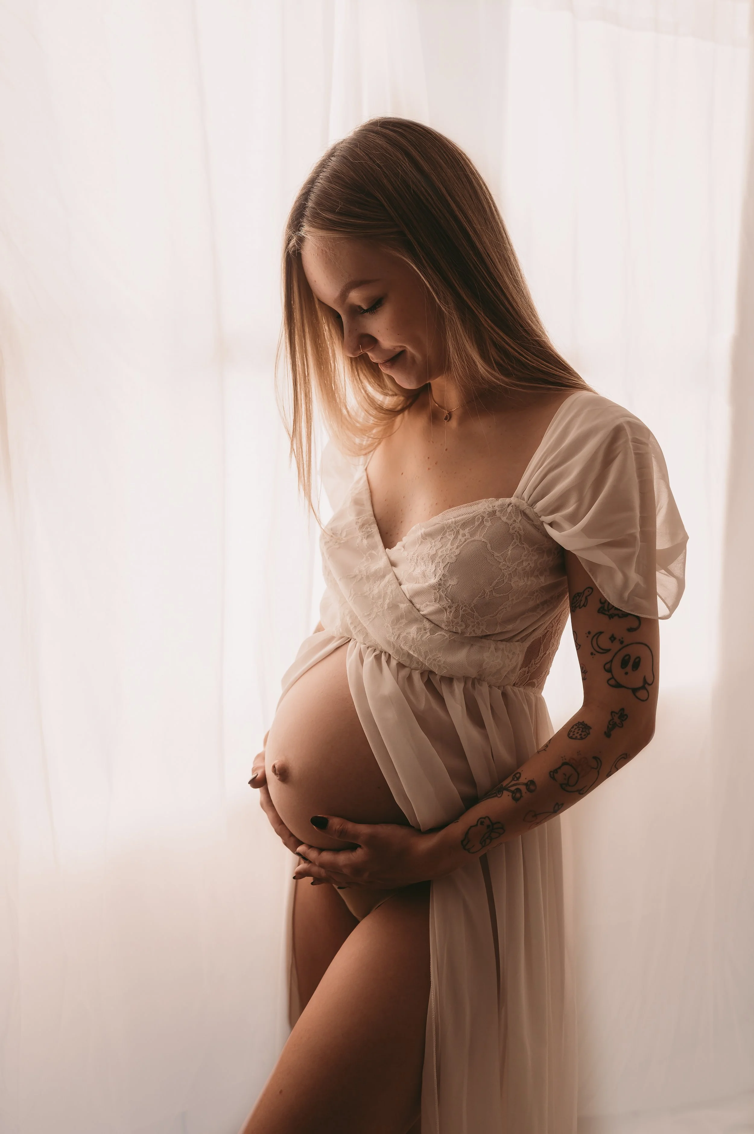A maternity photo showing off a small baby bump, wearing a open bump dress to show off bump,  Maternity photography by kp-photo, based in Wiltshire