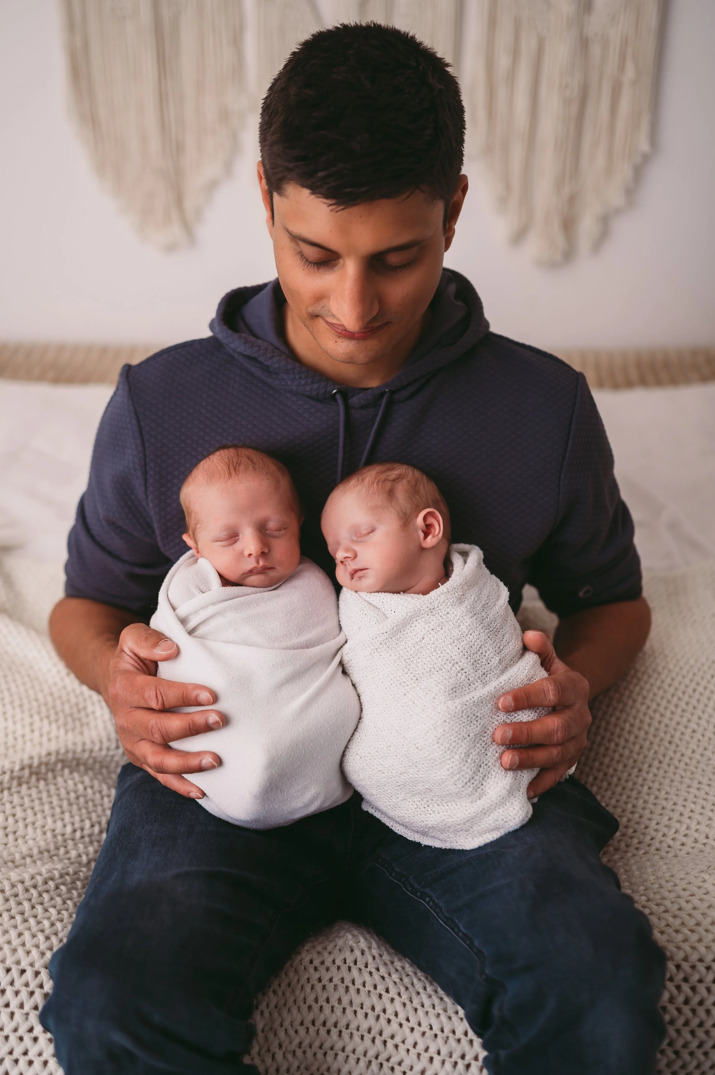 dad holding twin boys, wrapped in a swaddle and asleep, photographed in a studio by KP-Photo based in Trowbridge, Wiltshire