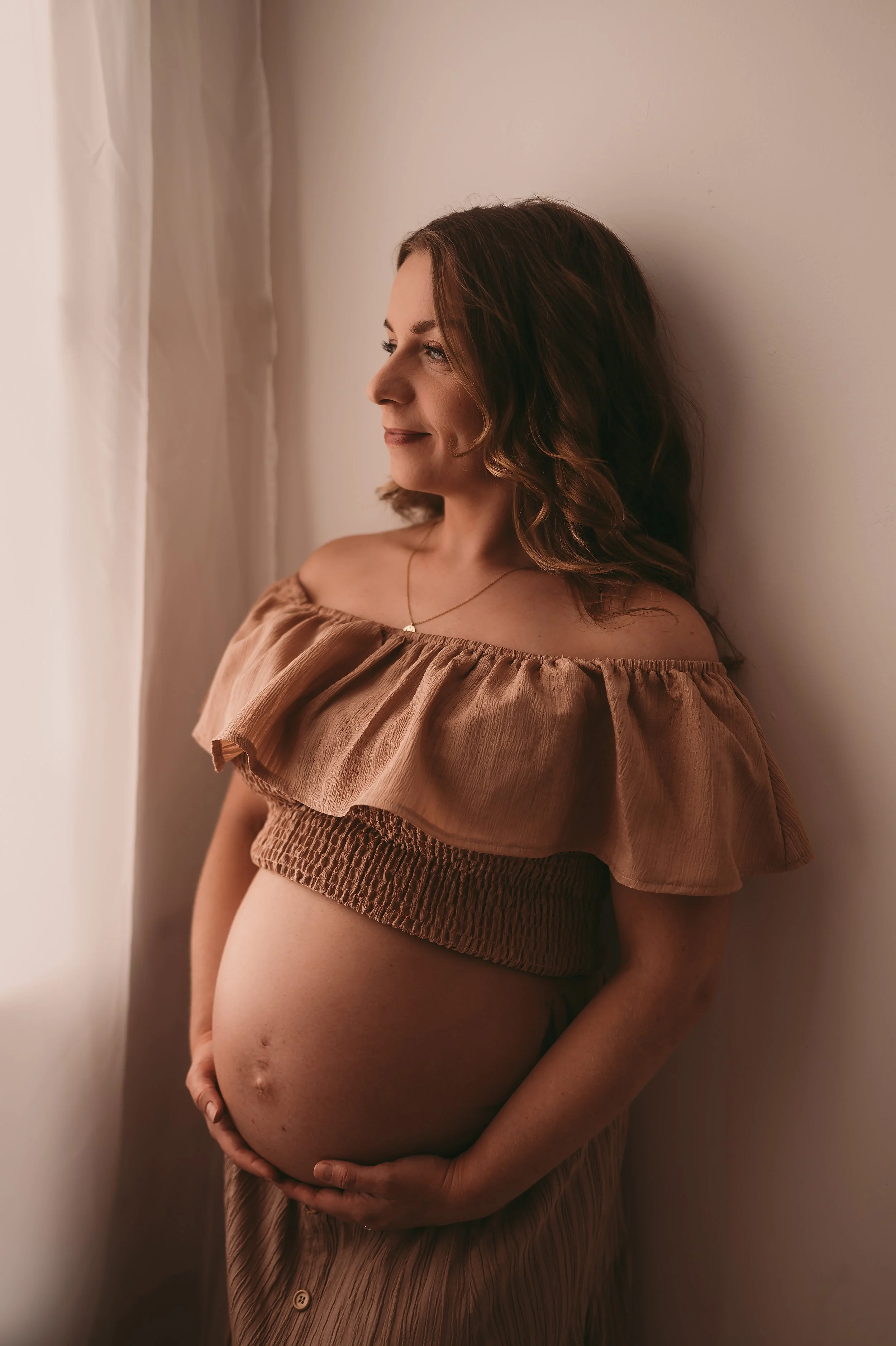 Pregnant Mother photographed in a studio near Somerset, wearing a two piece, crop top and skirt showing off baby bump
