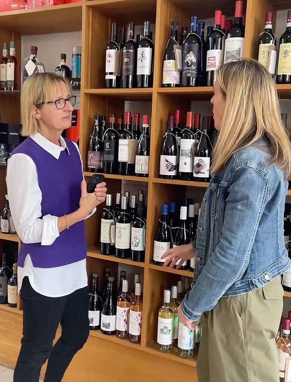Female point of sale researcher talks to a customer in a supermarket