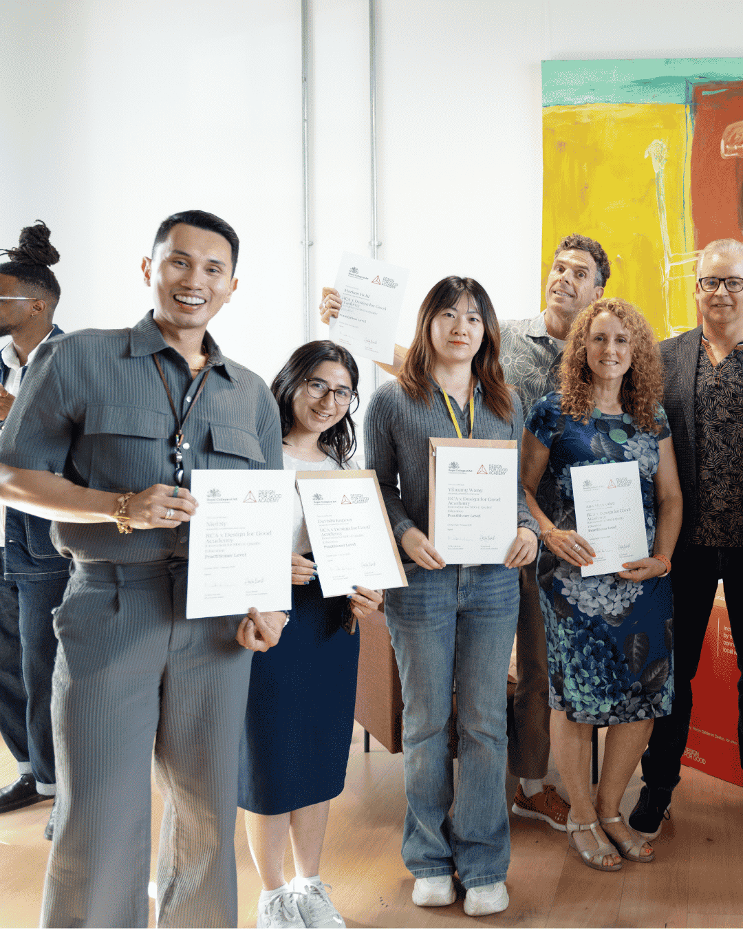 Group of four individuals holding Academy certificates.
