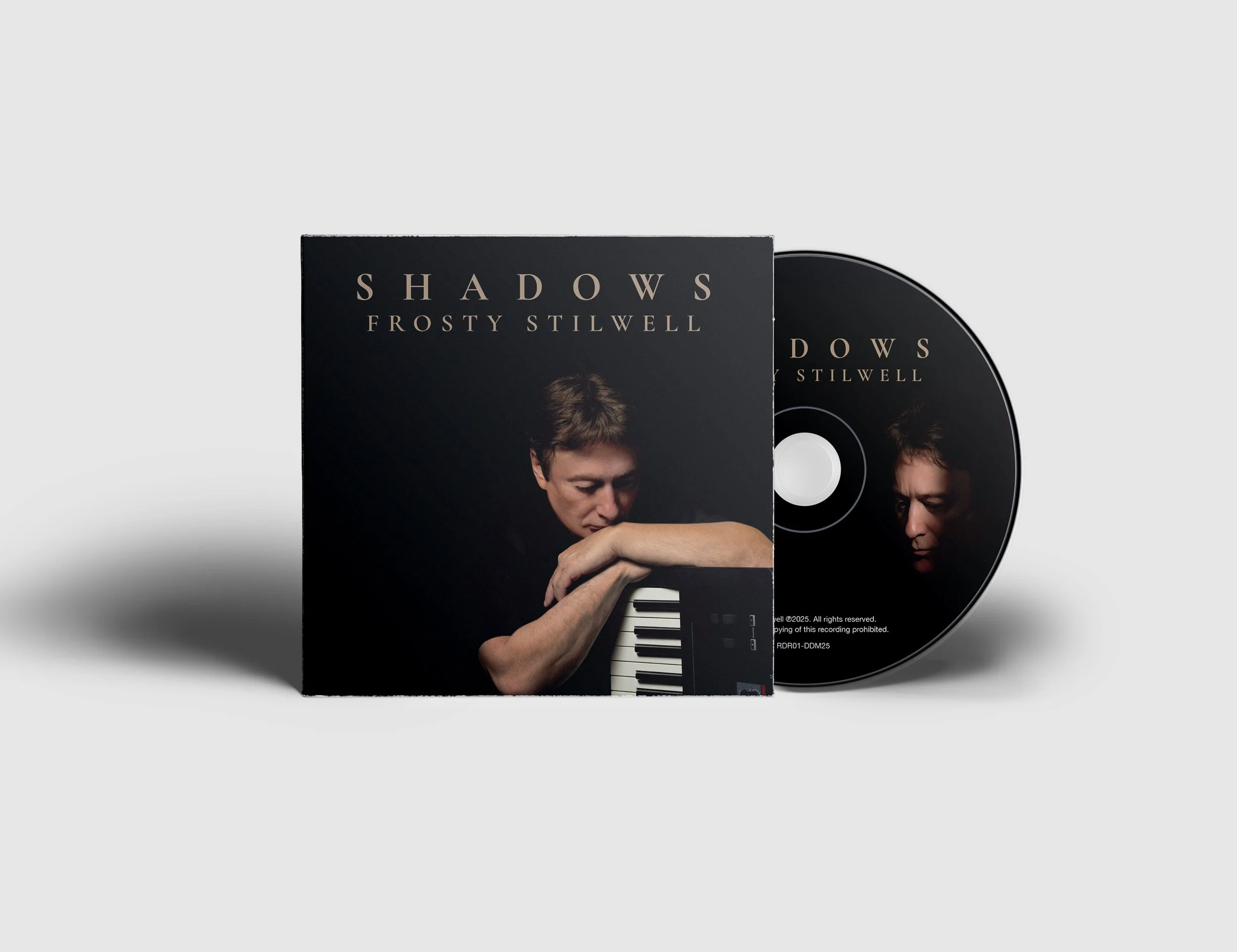 CD case and disc of Frosty Stilwell's album titled Shadows, with an artist portrait on the cover showing a woman resting her arm on a keyboard, against a black background