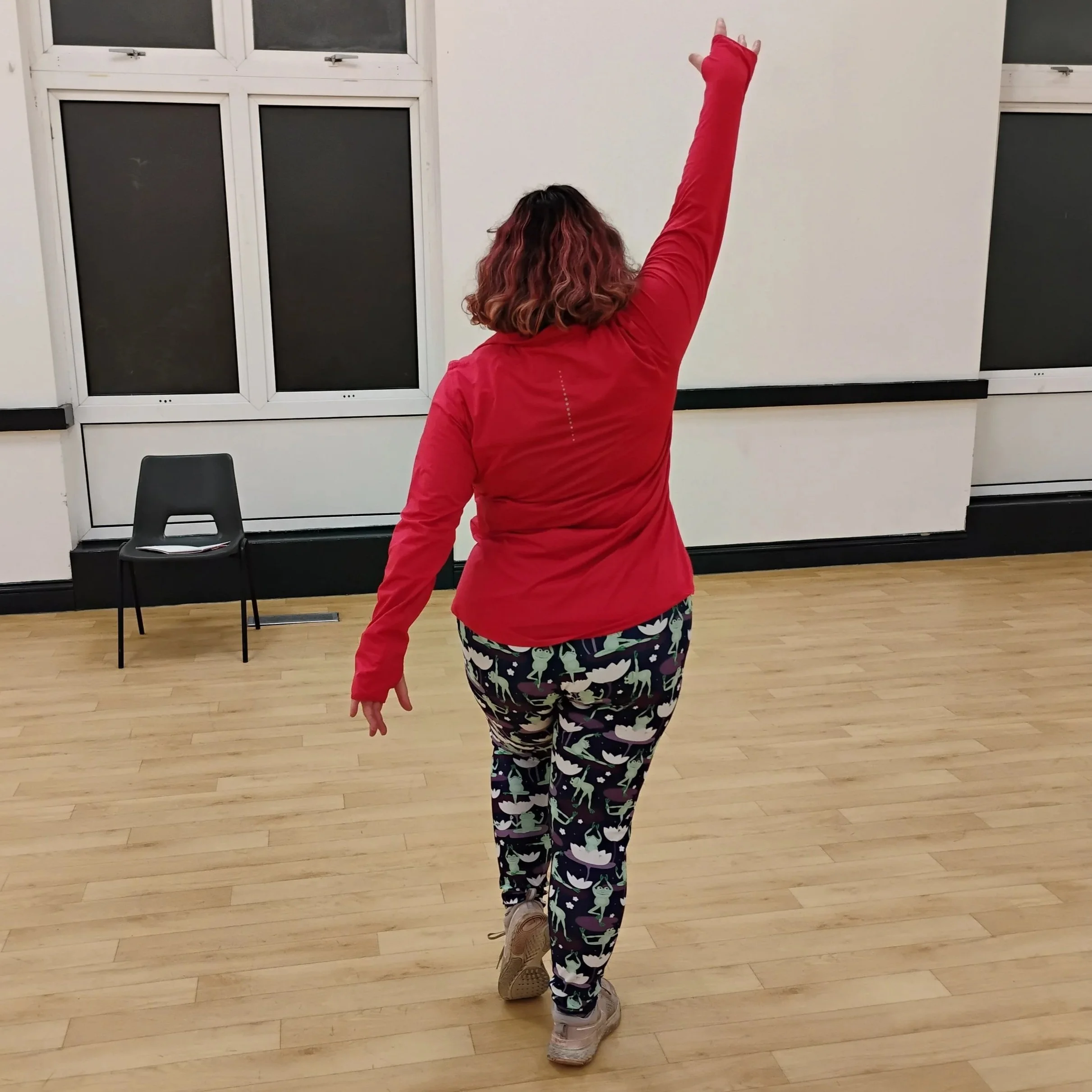 fat, white, female instructor facing away with arm raised