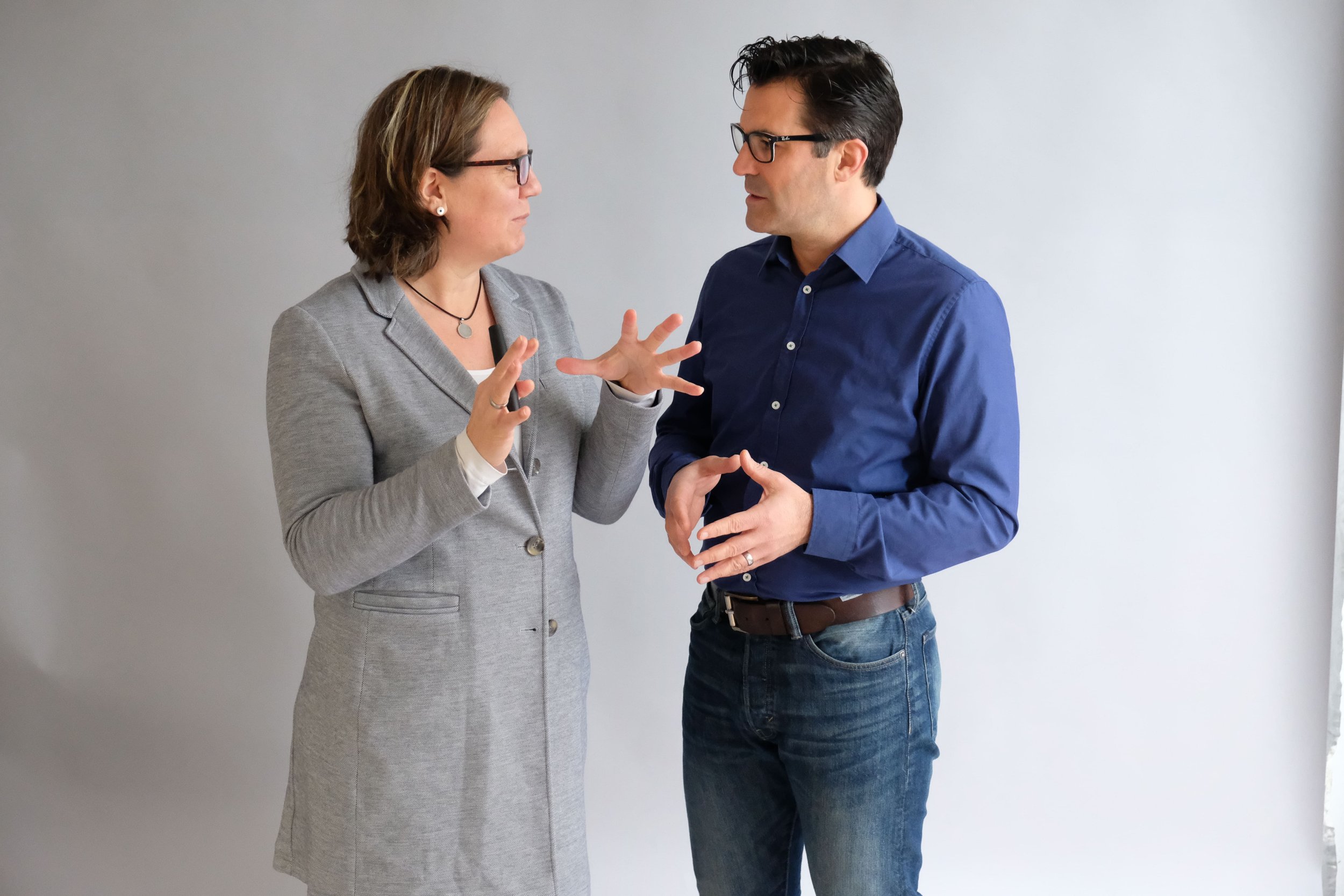 Zwei Führungskräfte schauen sich an und sind im Diskurs miteinander.