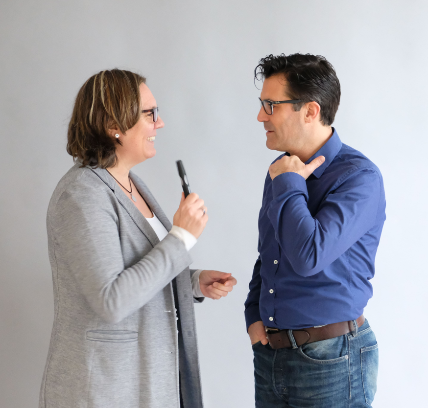 Zwei Führungskräfte im Gespräch, ein Symbol für klare und empathische Kommunikation im Programm Voice of Leadership.