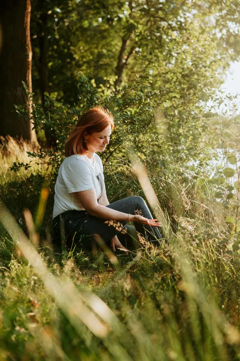 Vanessa Engling Coaching für Veränderung und ein bewusstes Leben sitzt auf der Wiese in der Abendsonne