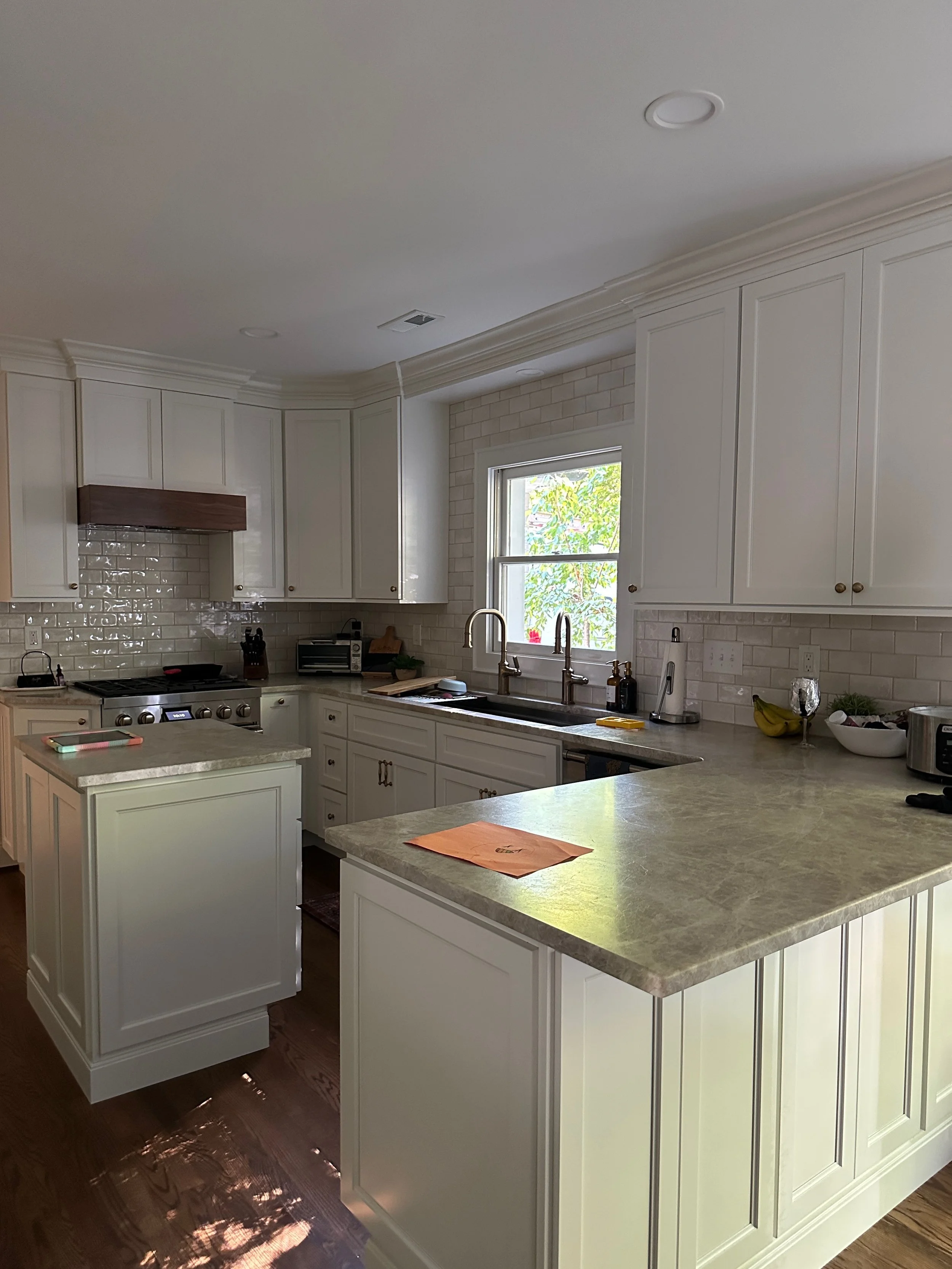 Walnut hood cabinet  Galley sink and leathered quartzite countertops in remodeled kitchen, Winston-Salem NC