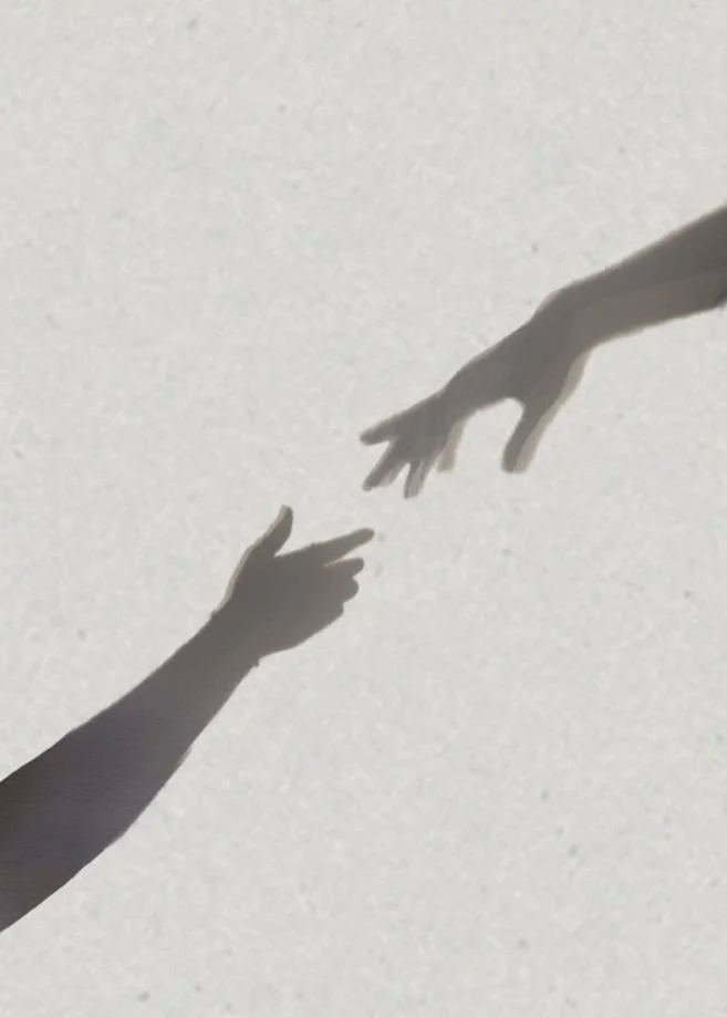 Ombres de deux mains qui se touchent.