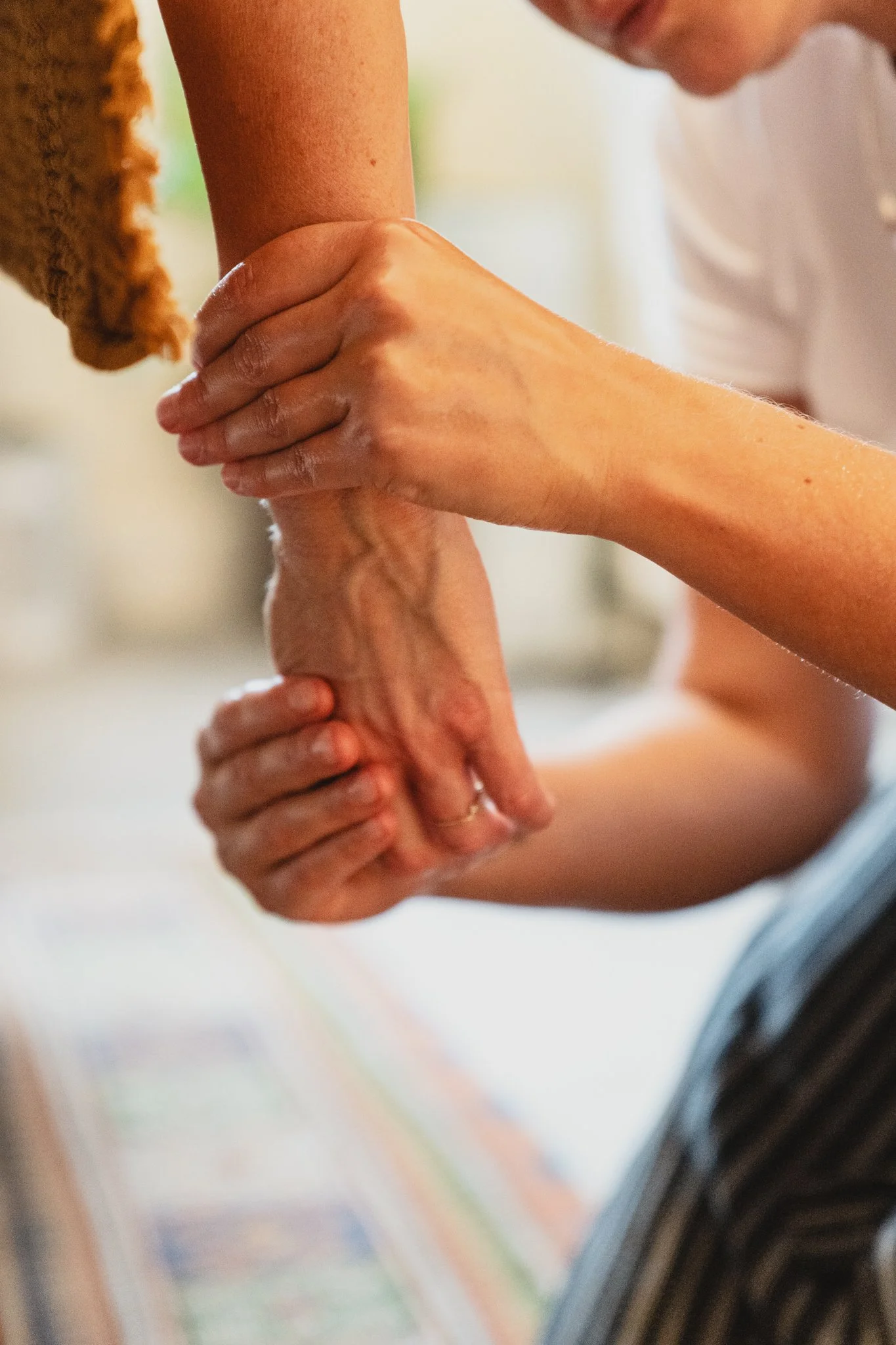 A person receiving a hand massage from another person indoors.