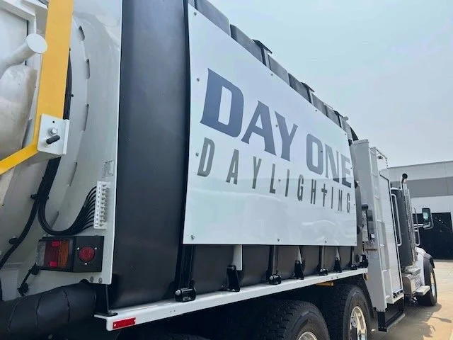 A large mobile lighting truck with a sign reading 'DAY ONE DAYLIGHTING' mounted on its side.