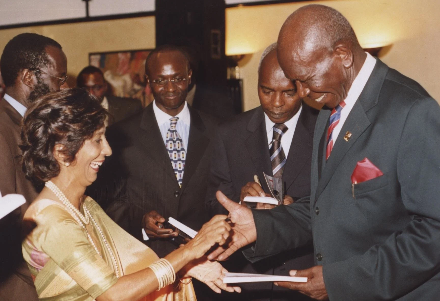 Author Sharmi Bhalla autographs a copy for Vice President Moody Awori.