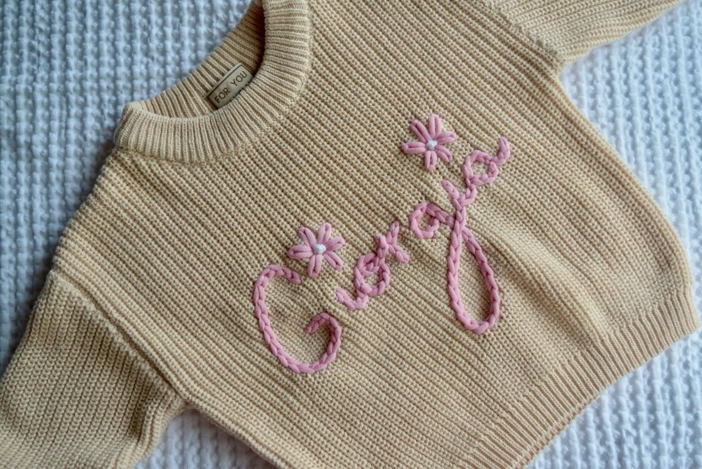 🌸 Giorgia 🌸

Sweet simple baby girl sweater! Love the subtle girly touch of the flower over the i 🫶🏻

Thin light pink font on cream sweater!