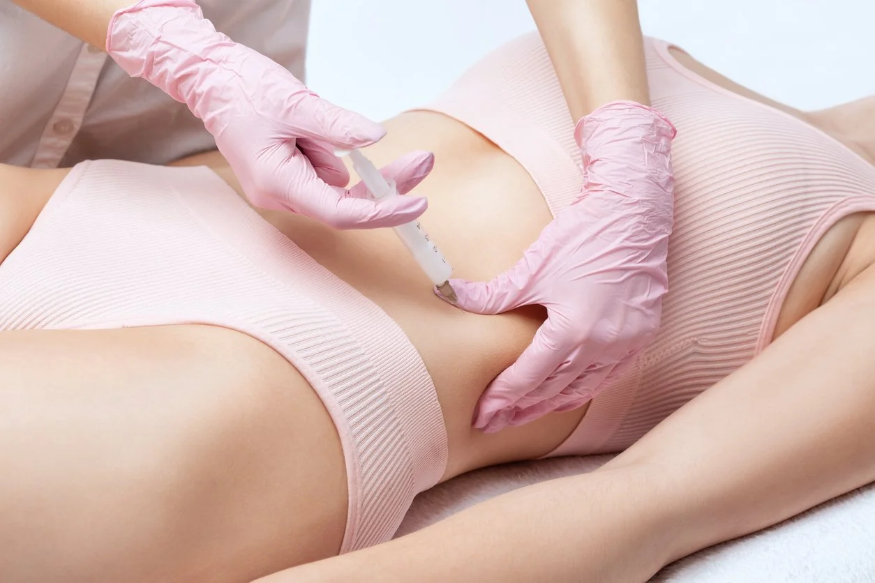 Beautician makes Kybella injection to a woman's stomach to promote fat loss