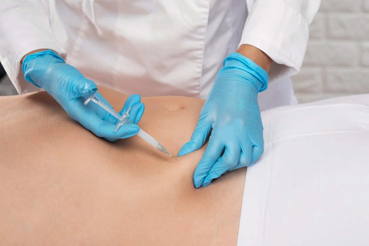 Aesthetician injecting person's stomach with semaglutide for fat loss
