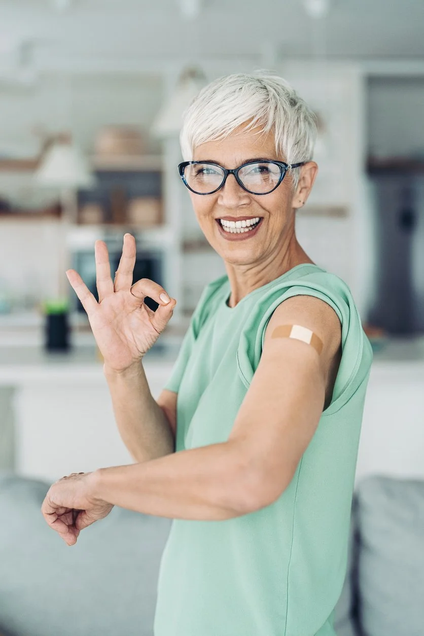 Older woman smiling and holding up the excellent sign after getting a vitamin injection in her arm