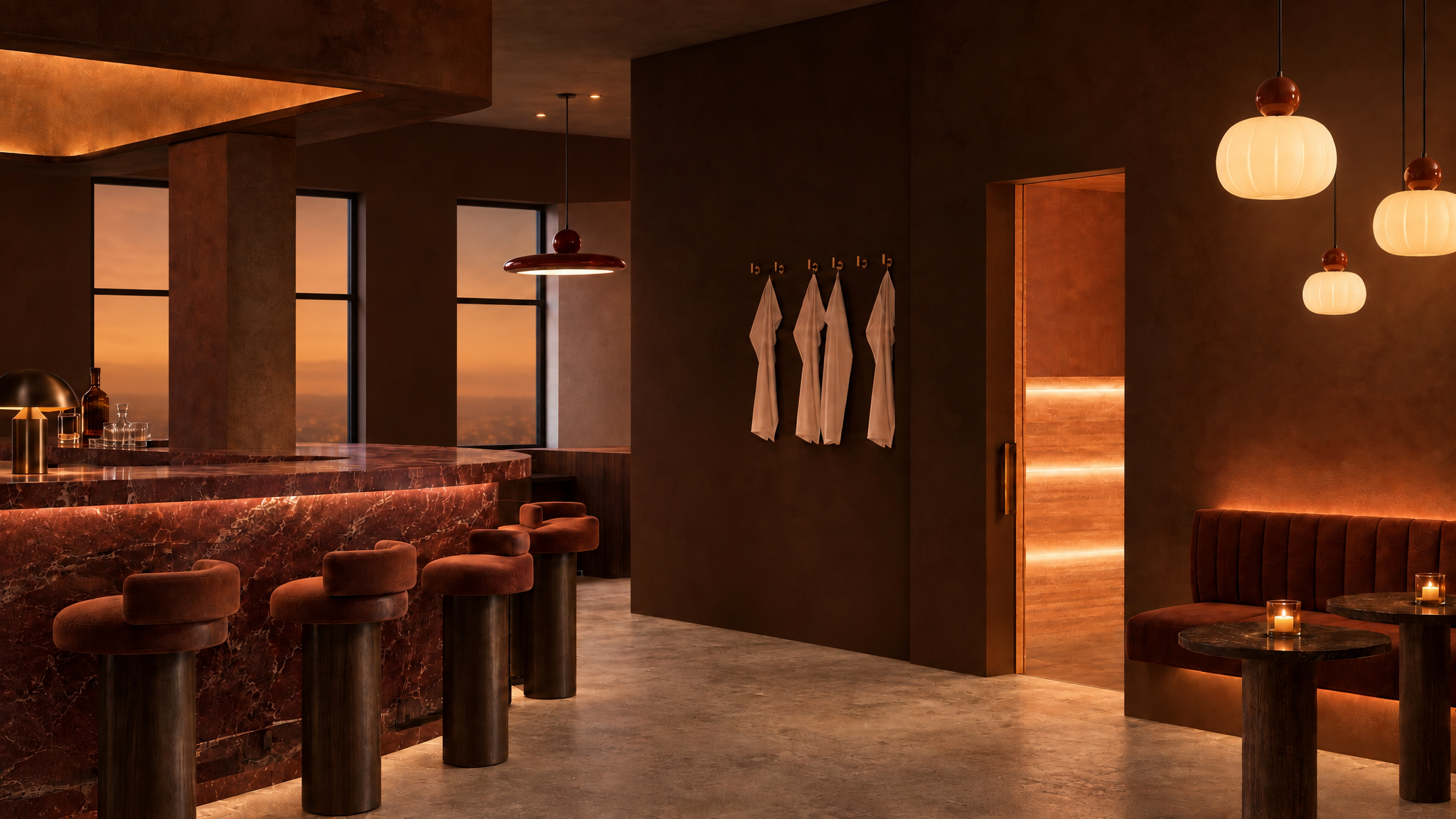 An elegant restaurant interior with warm lighting, marble bar counter, plush velvet chairs, black accents, and candles on small tables, featuring large windows showing a sunset sky.