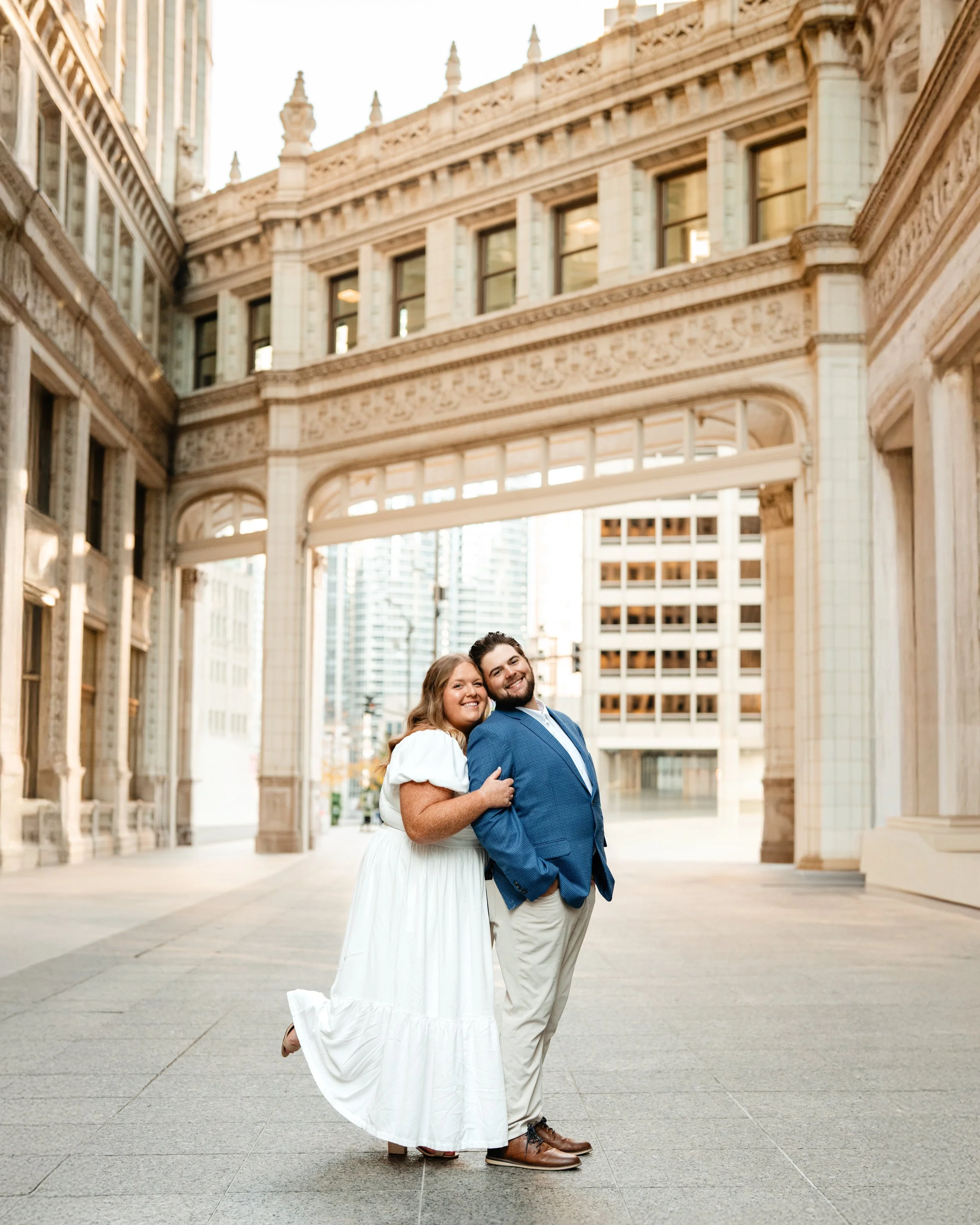 A man and woman dancing outdoors on a waterfront pier with a city skyline in the background.