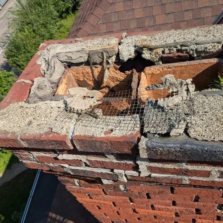 St. Paul homeowner inspecting an aging brick chimney, showing cracks and wear that indicate possible need for rebuilding.