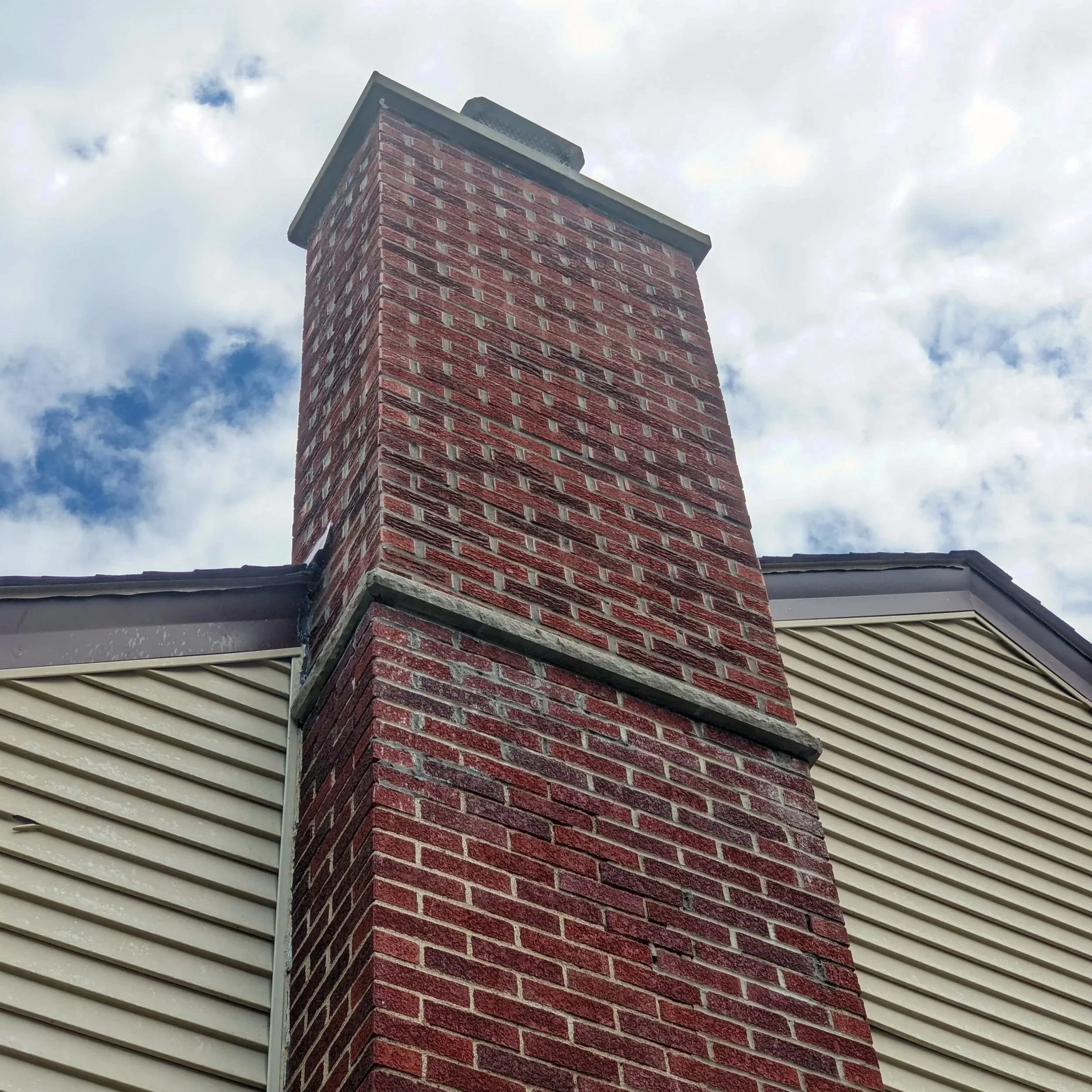 Technician inspecting a wood-burning fireplace chimney in a St. Paul home, ensuring proper maintenance for safety and efficiency.