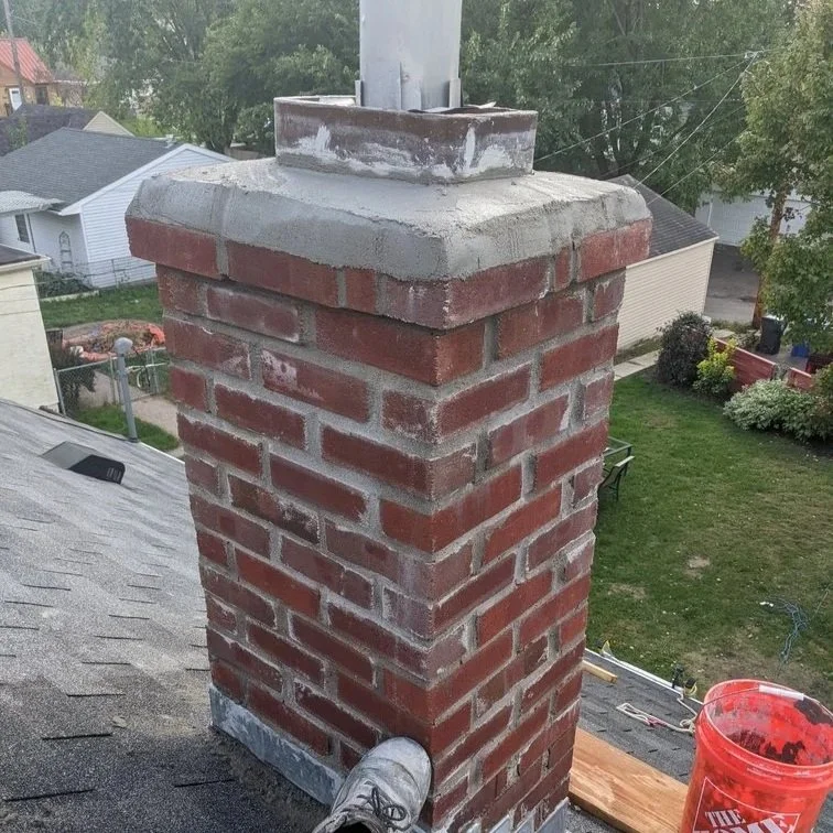 Professional inspecting a St. Paul chimney, checking bricks, mortar, and flue liner to prevent winter damage and hazards.