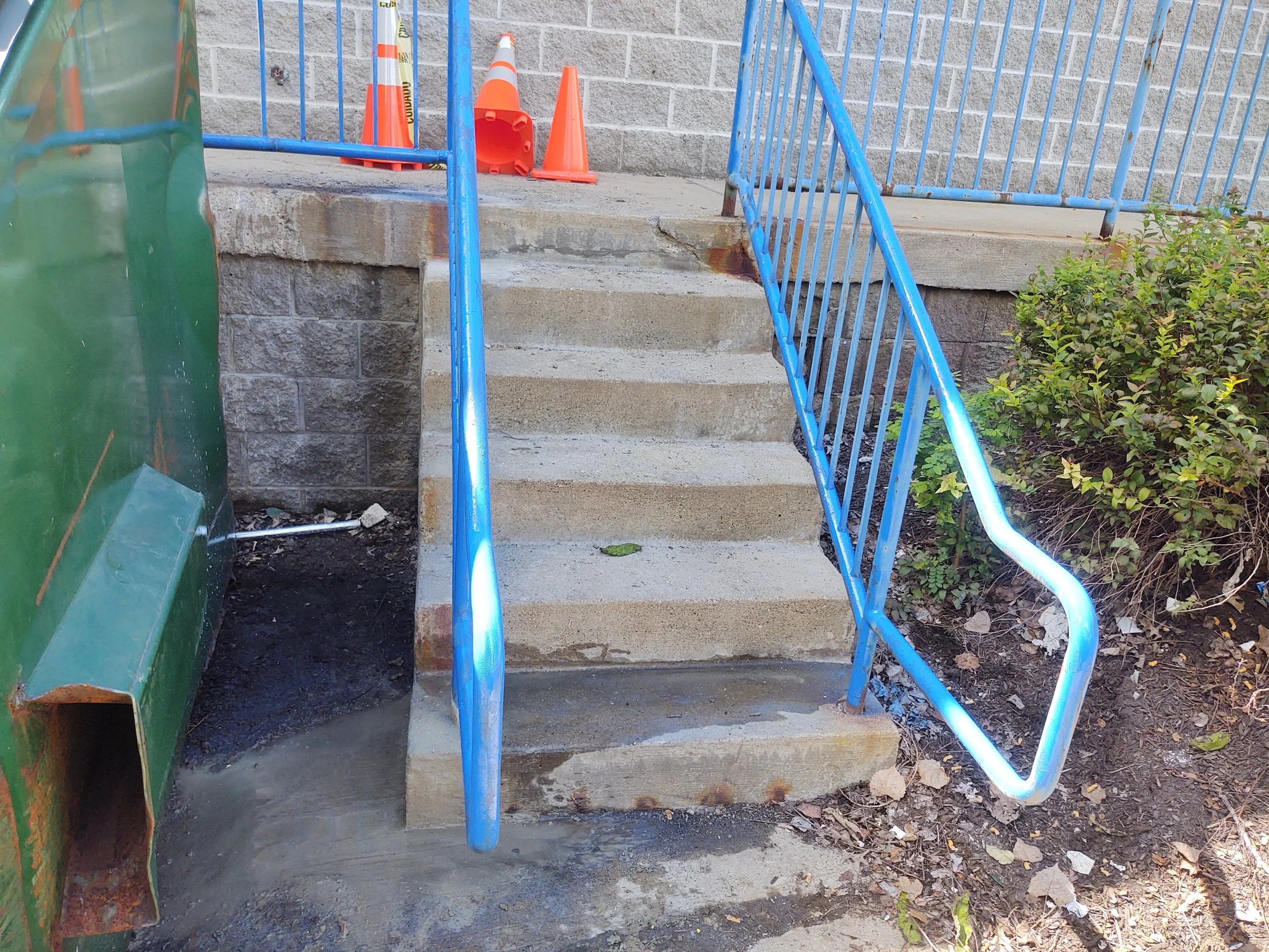 Newly repaired and painted blue metal safety handrail on outdoor concrete stairwell by R.P.W. Contracting in Jeannette PA