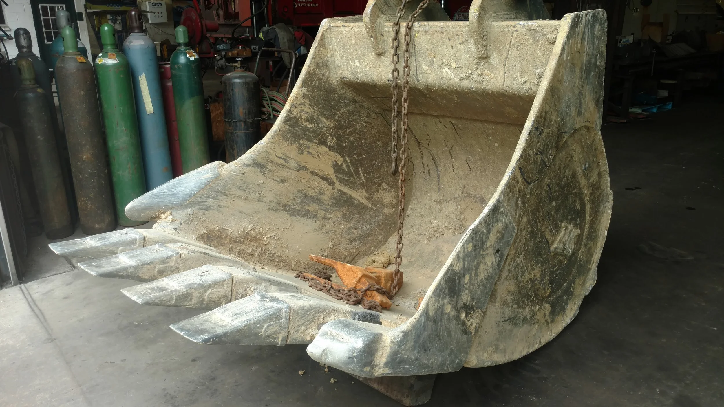 Worn heavy equipment bucket awaiting repair at RPW Contracting in Jeannette, PA — excavator bucket pickup, welding, and restoration service