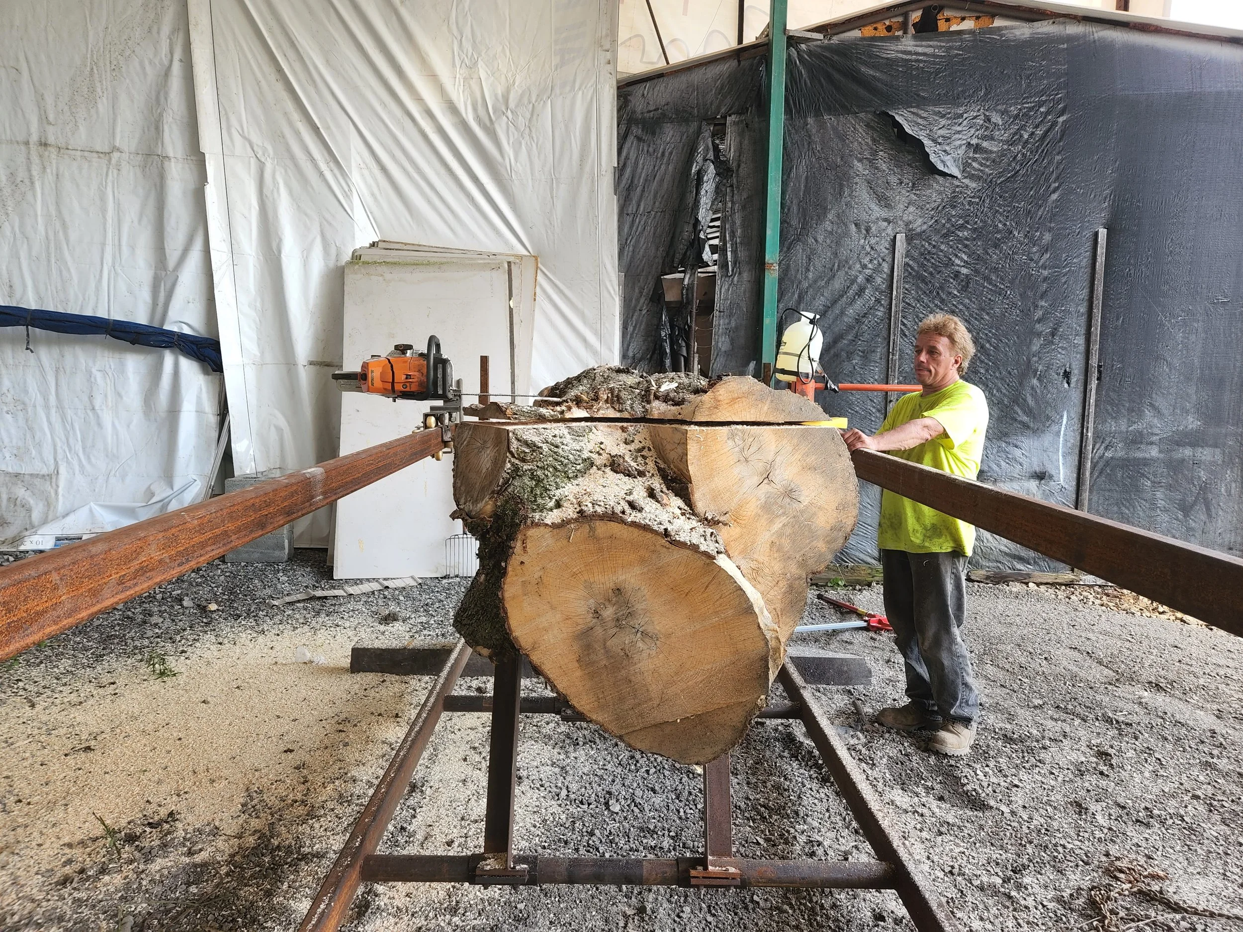 RPW Contracting team member using a custom chainsaw mill to process large tree logs for on-site lumber and tree removal services in Jeannette, PA