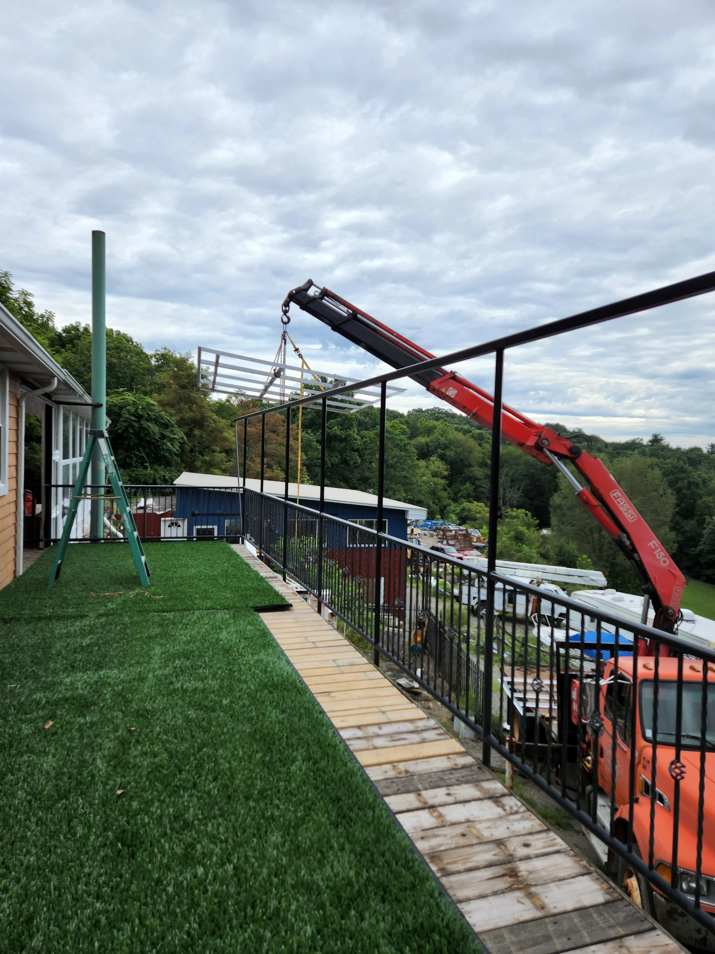 RPW Contracting using knuckle boom crane to install custom metal hand railing in Jeannette, PA — expert residential and commercial railing installation