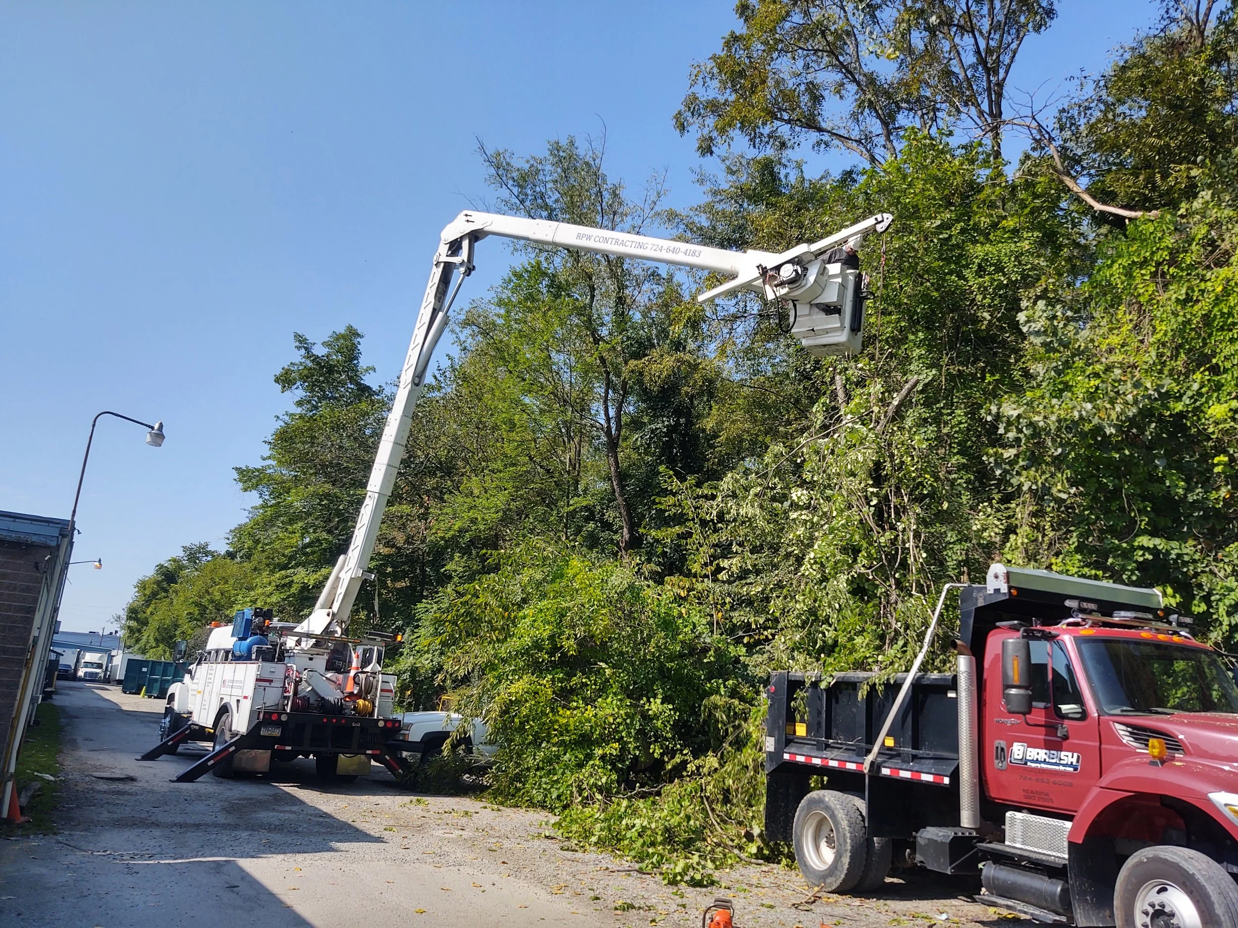 RPW Contracting bucket truck clearing trees at commercial site in Jeannette, PA – affordable emergency tree removal and trimming service