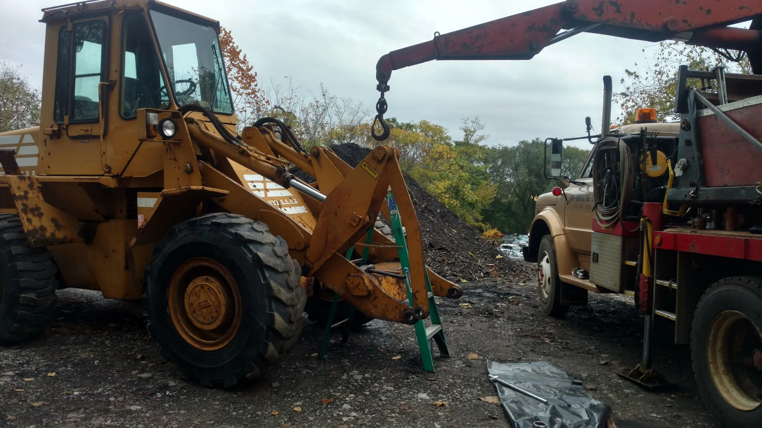 Hydraulic cylinder removal from heavy equipment loader during on-site mobile welding service by R.P.W. Contracting in Jeannette, PA