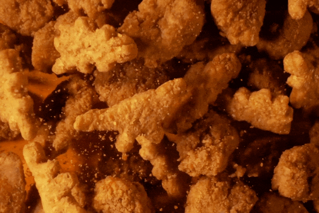Close-up of fried chicken pieces with seasoning and sauce.