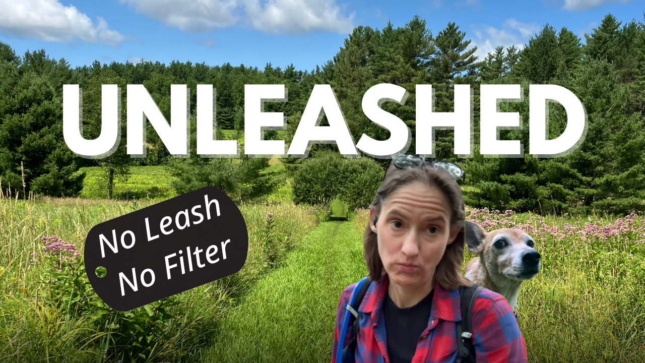 A woman and her dog standing on a grassy trail in a lush green forest, with bold text reading 'UNLEASHED' and a tag that says 'No Leash No Filter'.