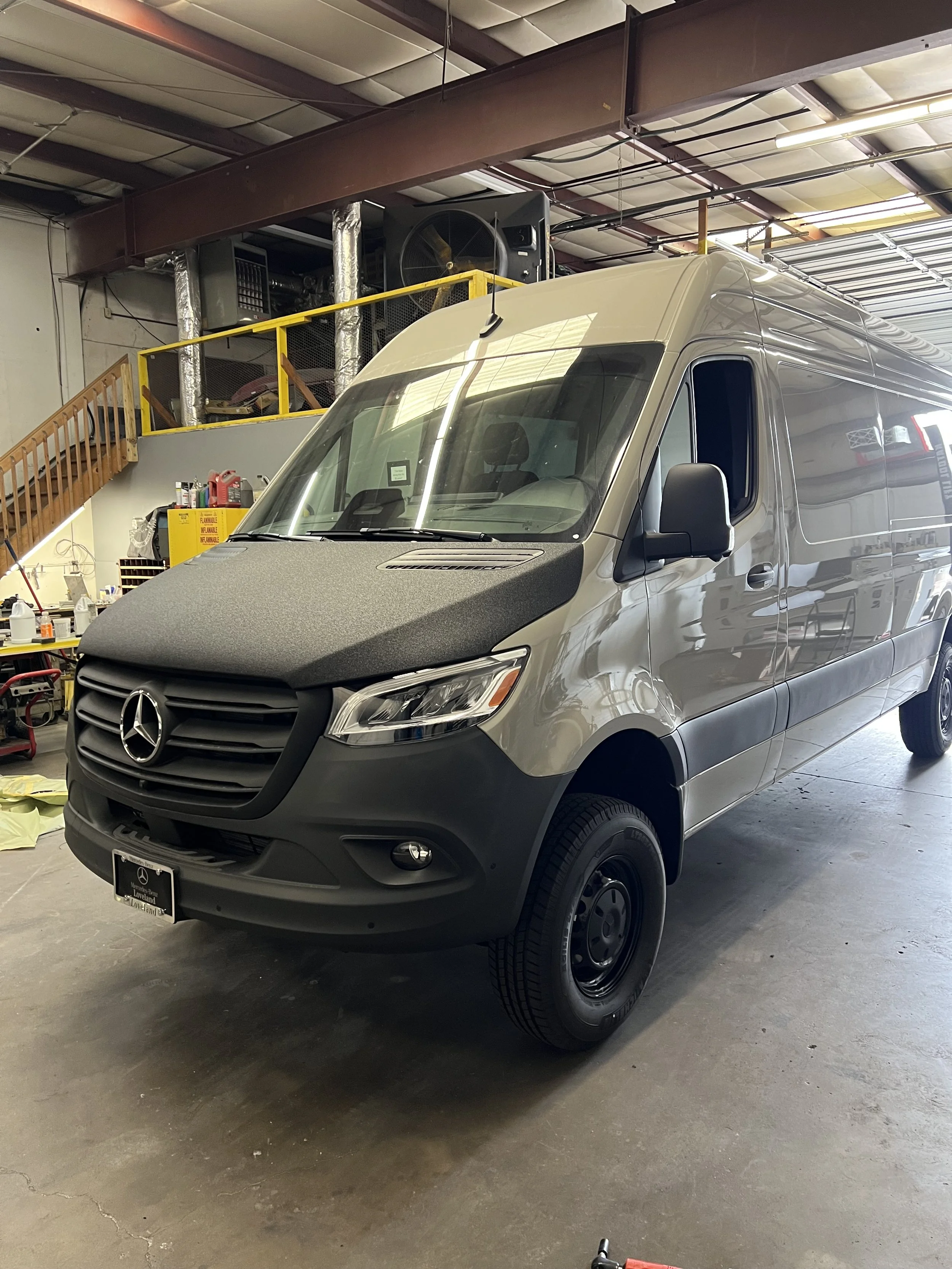 Gray Mercedes-Benz Sprinter van inside a workshop or warehouse.